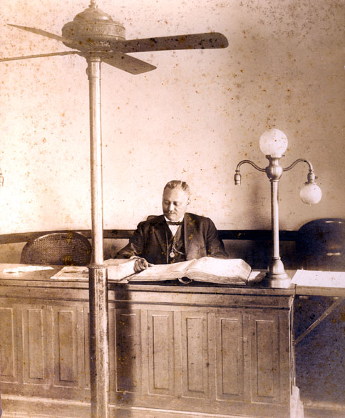 African-American man in suit and bow tie sitting in a courtroom