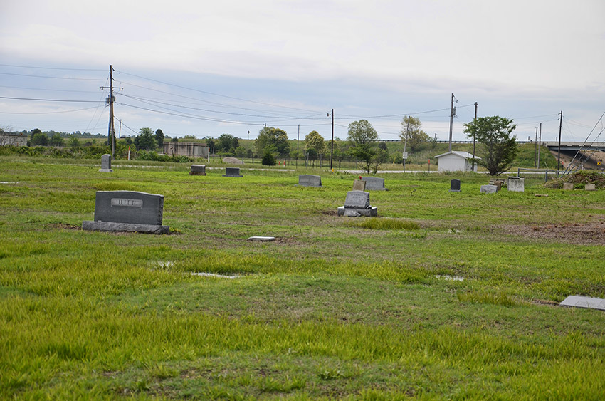 Gravestones in cemetery with highway bridge in the background