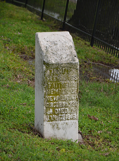 Weathered stone memorial with raised engraving on grass