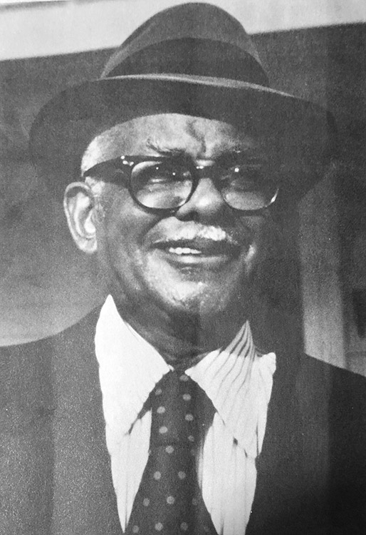 Older African-American man smiling in hat and glasses