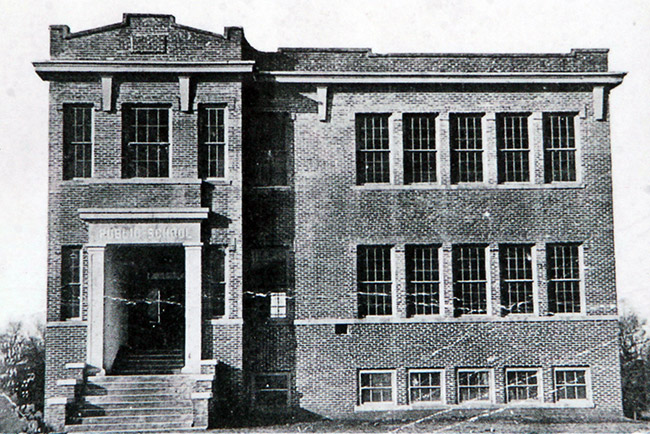 Three-story brick school building with rectangular windows