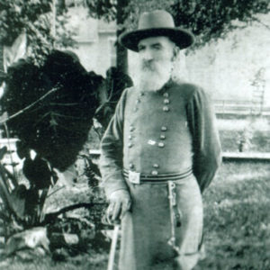 Old white man with long beard, hat and sword in Confederate uniform
