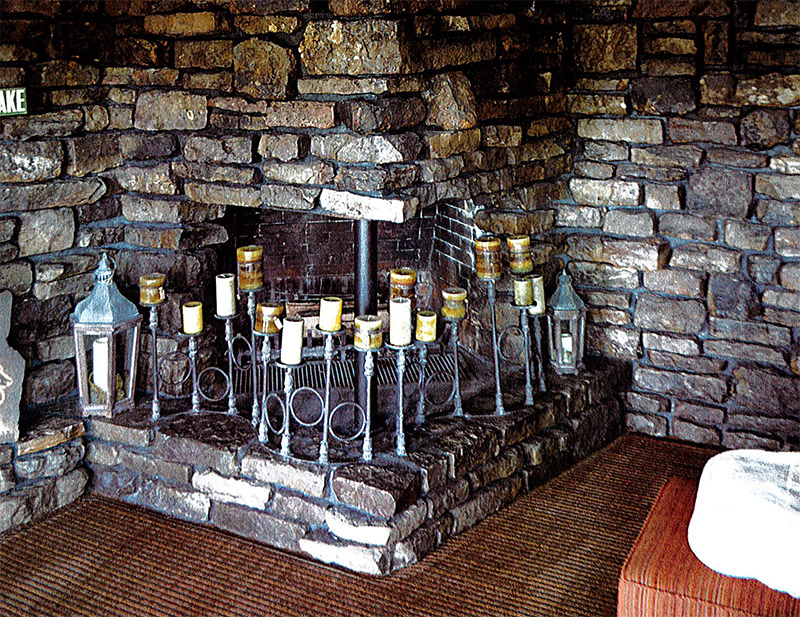 Rock fireplace with candles in house