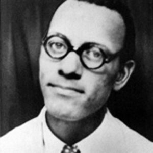 African-American man with round glasses in suit and tie