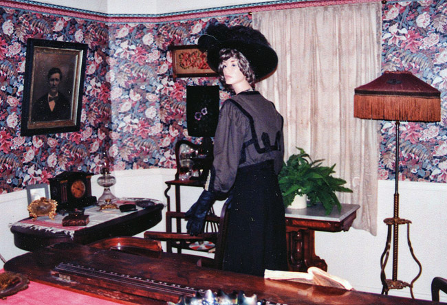 Mannequin in hat and dress in Victorian parlor room