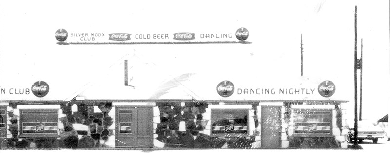 Exterior of single-story dancing club building with Coca-Cola advertisements on it