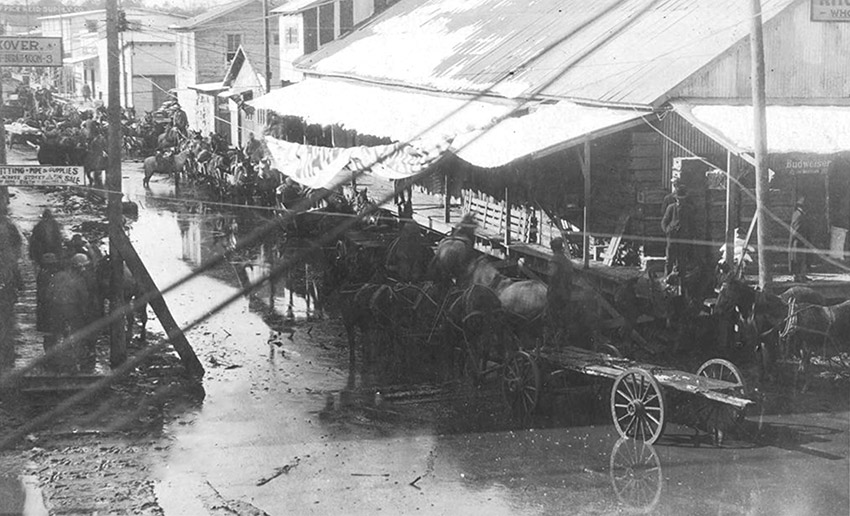 Flooded street with people, horses, and wagons