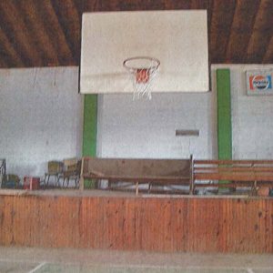 Close-up of basketball hoop and stage area in gymnasium