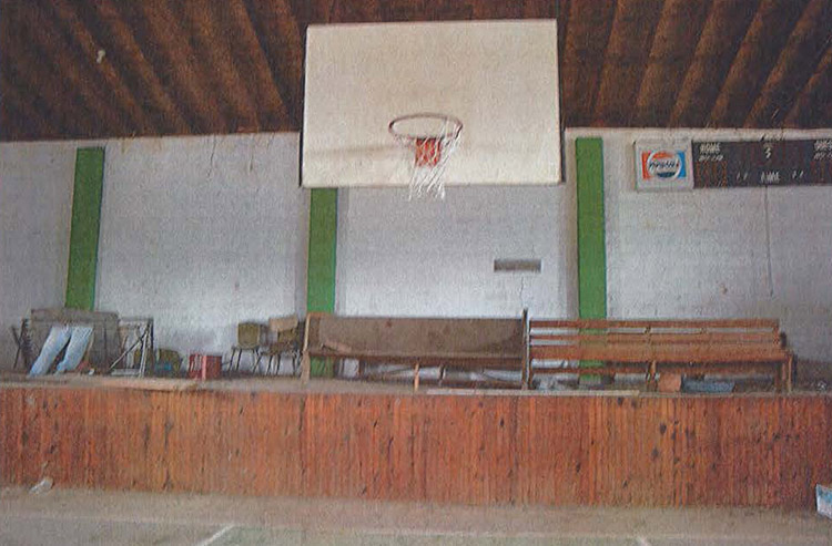 Close-up of basketball hoop and stage area in gymnasium