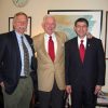 Group photo three white men in suits ties in office by Arkansas map and clock