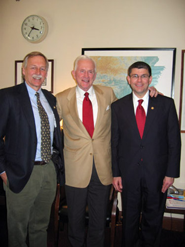 Group photo three white men in suits ties in office by Arkansas map and clock