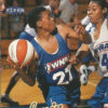 African-American woman in blue uniform passing ball