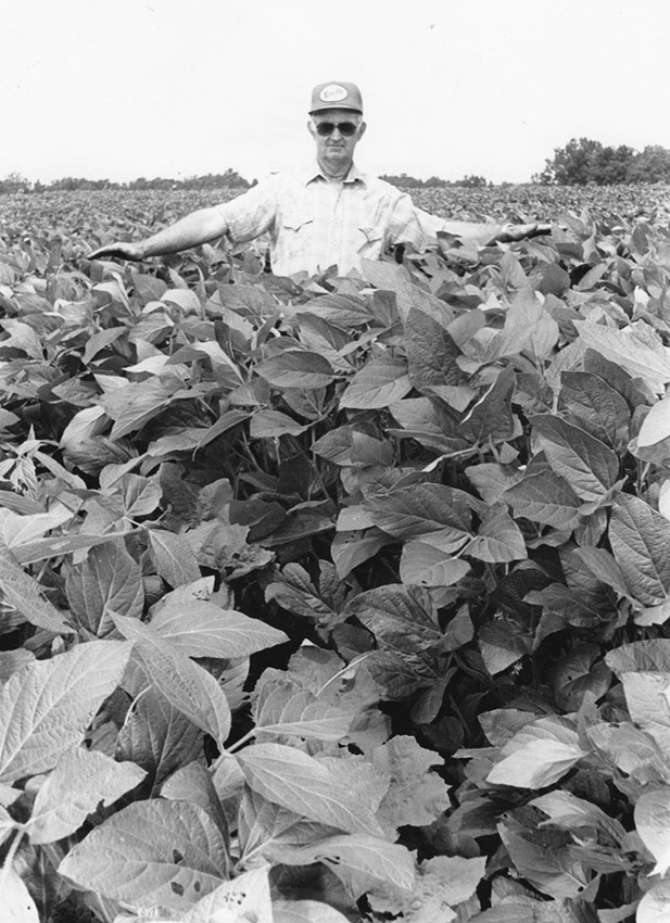 White man standing in field of plants