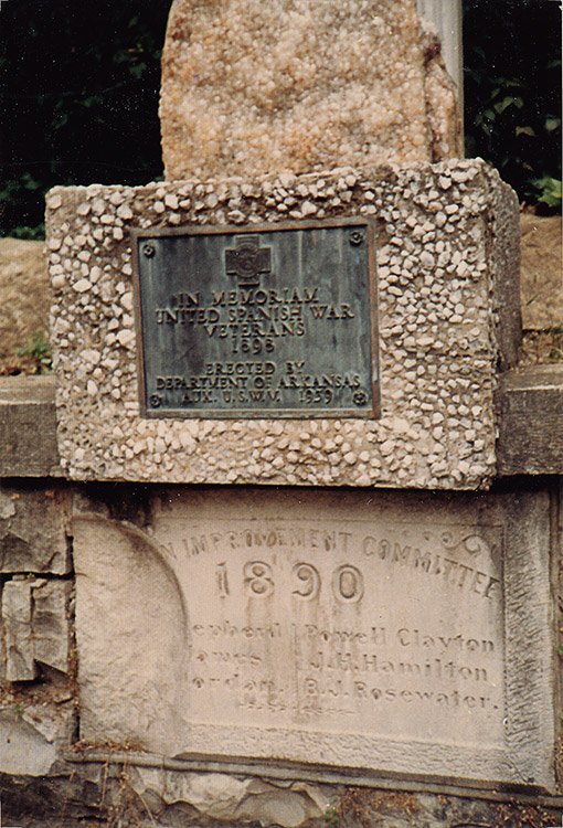 Stone memorial with weathered plaque and engraved base