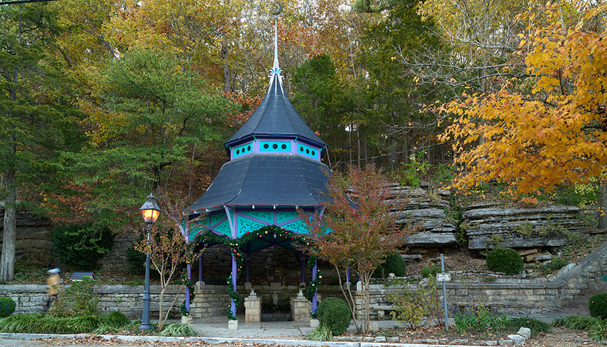 Gazebo over grotto with decorative brick walls and street lamp
