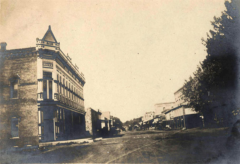 Multistory buildings and storefronts with covered entranced on dirt road