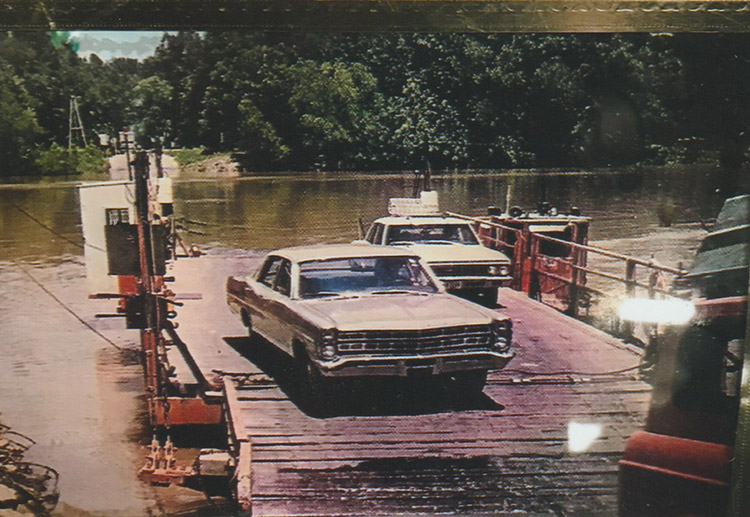 Two cars driving off river ferry