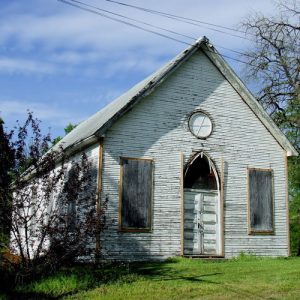 Single-story church with arched entrance in state of dilapidation