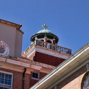 Cupola with cross on roof of brick building