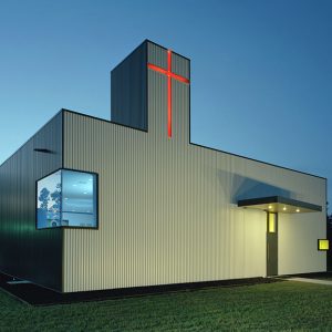 Modern box-shaped church building with red cross and corner windows