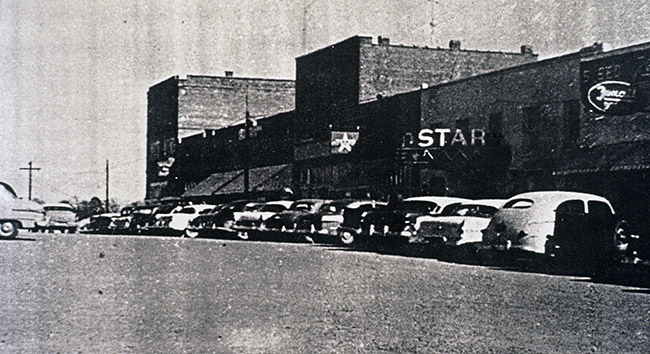 Street and brick storefronts with "Star" theater and parked cars