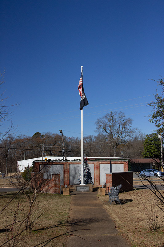 Flagpole partially surrounded by brick structure