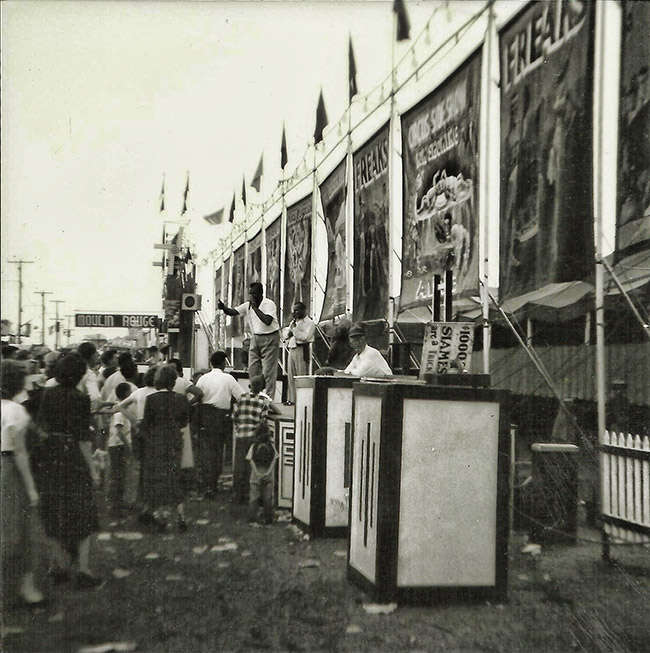African-American performers on platform with crowd and large banners behind them and sign saying "Moulin Rouge"