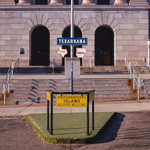 Texarkana Texas and Arkansas border sign outside multistory building with stairs