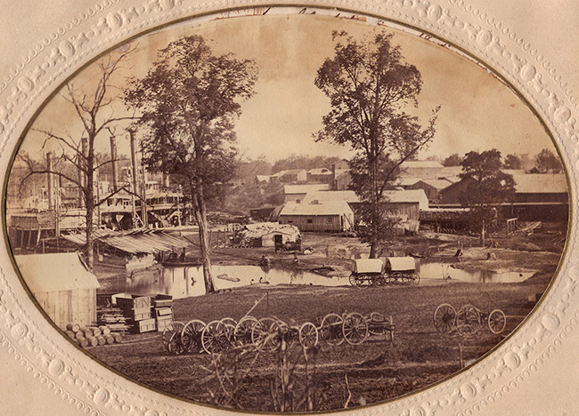 Steamboats at port with town buildings and cannons in foreground