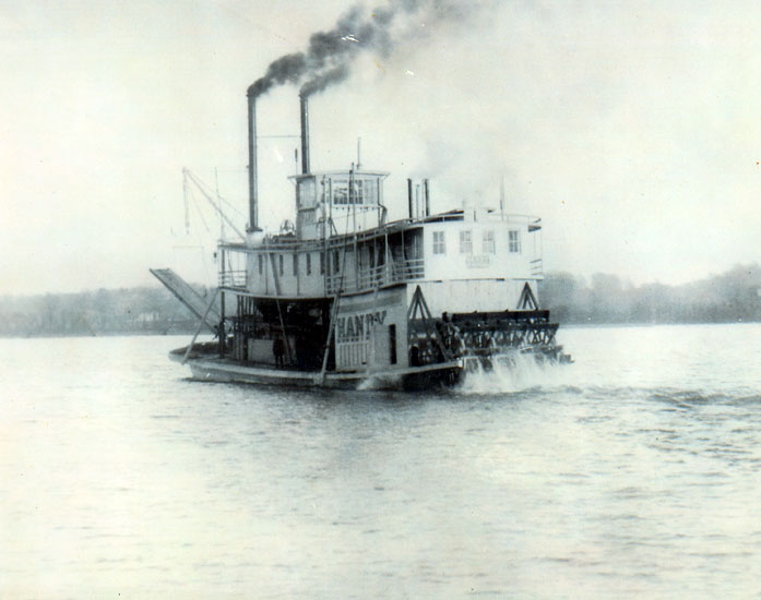 Steamboat "Handy" on a river with trees in the background