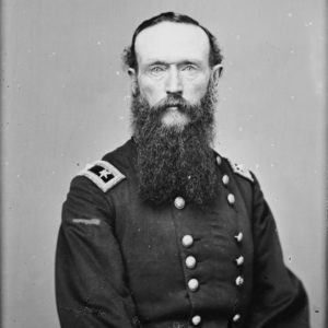 White man with long sideburns and beard in military uniform