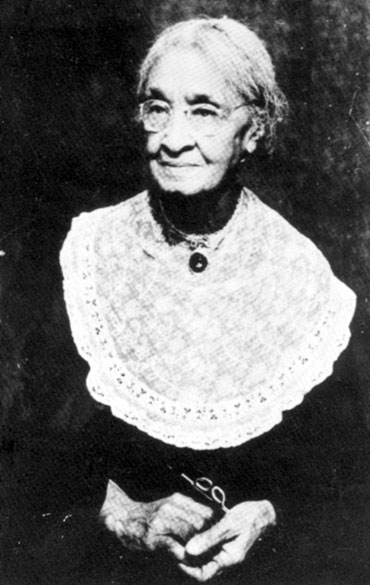 African-American woman with glasses in lace-collared dress
