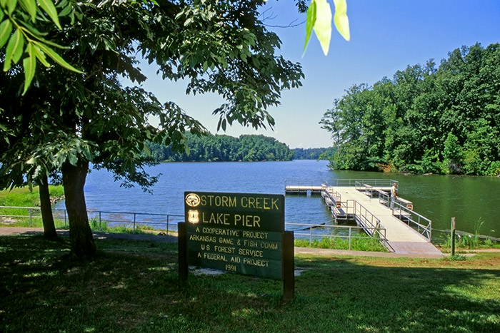 Lake with park sign trees and boat dock