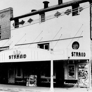 Two-story theater with "Strand" written on the awning