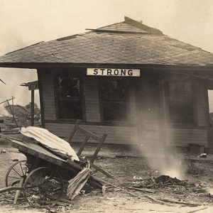 Damaged train depot building and debris in the foreground