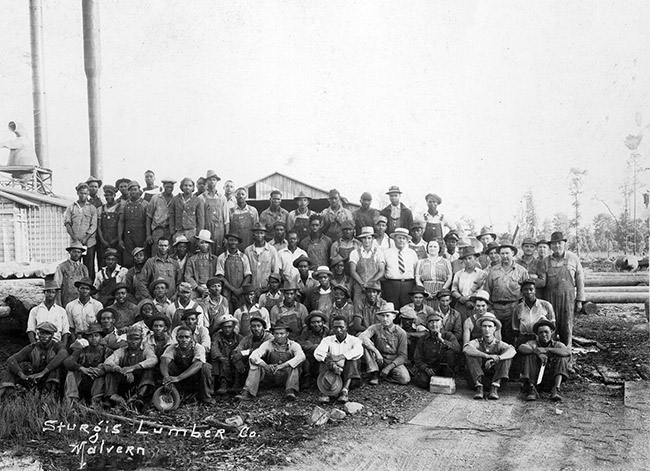 Group of white and African-American workers at lumber mill