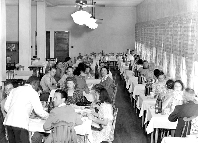 African-American man in uniform serving white men and women in dining hall