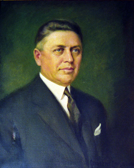 White man in suit with green background