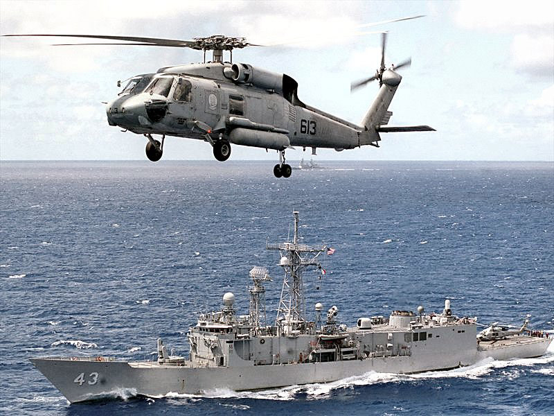 Helicopter flying over ship at sea