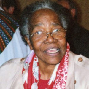 Older African-American woman with glasses with crowd behind her