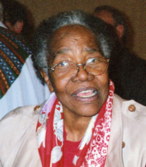 Older African-American woman with glasses with crowd behind her