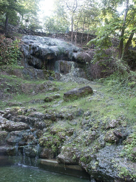 Natural waterfall with rocks and trees on hillside