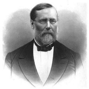 White man with beard and glasses in suit and bow tie