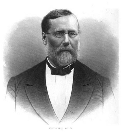 White man with beard and glasses in suit and bow tie