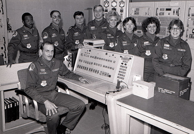 Group of men and women in U.S. Air Force uniforms in computer room