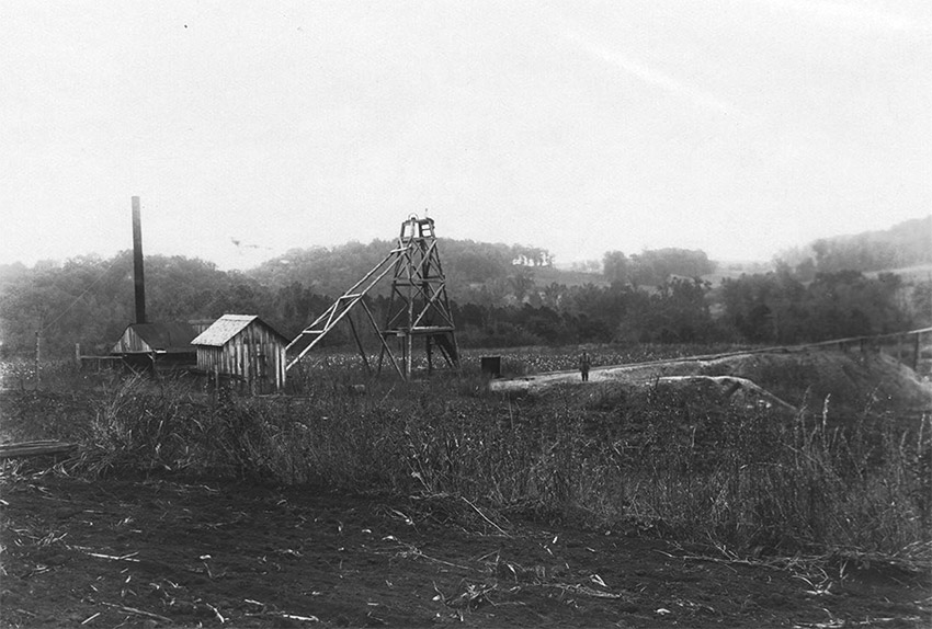 Wooden structure and cabins with smokestack in field