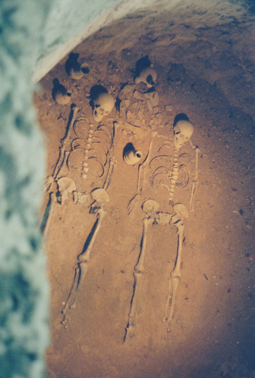 Skeletal remains in grave with clay pottery