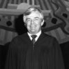 White man smiling in judge's robe