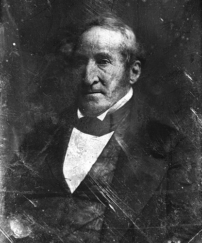Portrait older white man thin hair long sideburns in suit and tie