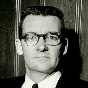 White man wearing glasses in suit and tie